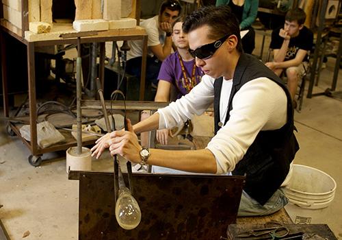 Students working with glass in the workshop.